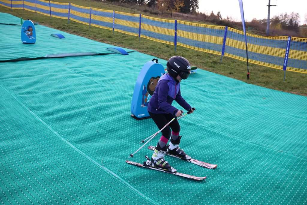 Kind fährt auf Skiern über die Mattenpiste